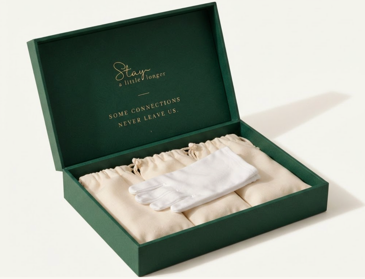 Stay design preview: open emerald keepsake box with gold lettering, cream pouches, and white gloves.